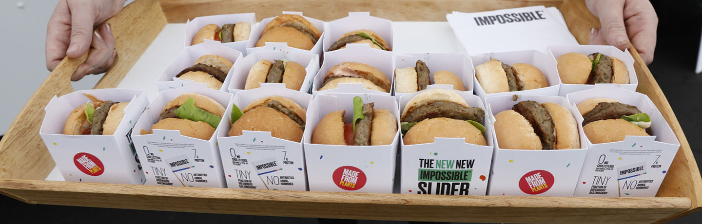 ALT Text: a person holding a tray of 16 impossible burgers (fake meat) individually wrapped 
