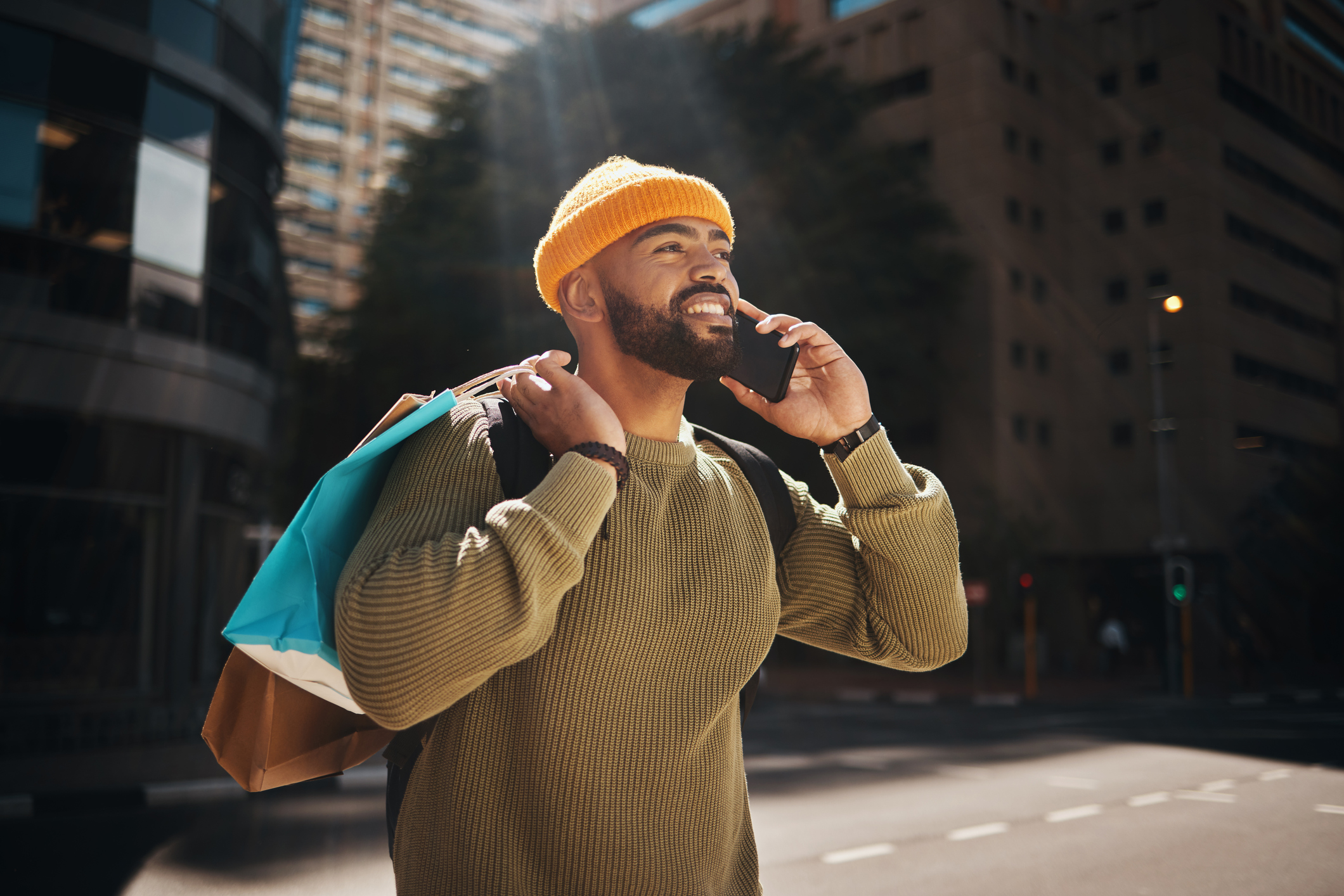 Alt Text: Man, phone call and shopping in city with travel, walking and talking of student deal, discount or online sale in street
